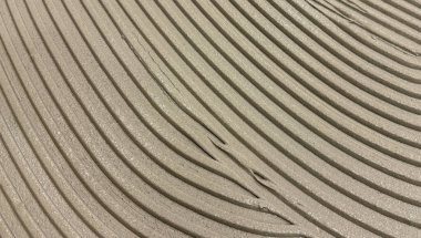 Dikey bej çizgileri ve yumuşak gölgeleri olan desenli yüzey, soyut mimari arka grup