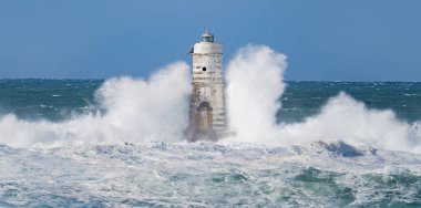 Güçlü okyanus dalgaları ağır deniz fırtınası sırasında ıssız deniz fenerine çarpıyor.