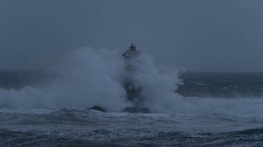 Güçlü okyanus dalgaları ağır deniz fırtınası sırasında ıssız deniz fenerine çarpıyor.