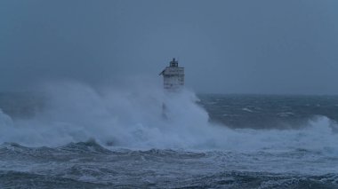 Güçlü okyanus dalgaları ağır deniz fırtınası sırasında ıssız deniz fenerine çarpıyor.