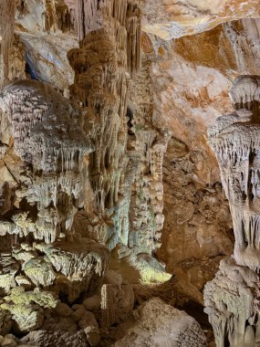 Ispinigoli Mağarası 'nın içinde yumuşak ışıklarla aydınlatılmış görkemli sarkıtlar ve dikitler.