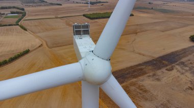 Altın tarım arazisindeki rüzgar türbininin havadan görünüşü yenilenebilir temiz enerjiyi teşvik ediyor