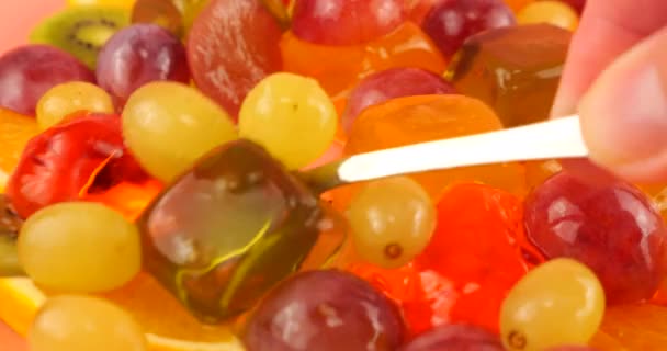 Multi Gekleurde Bessengelatine Gelei Met Druiven Sinaasappelschijfjes Kiwi Een Roze — Stockvideo