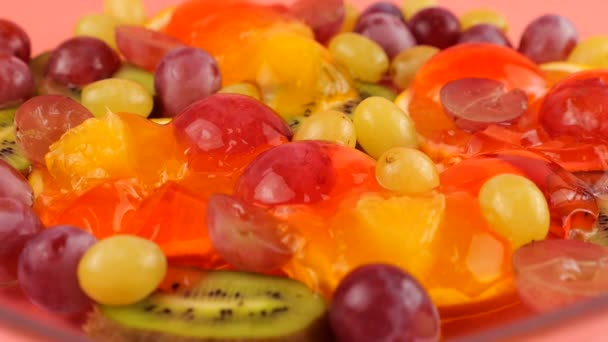 Vallende Druiven Een Veelkleurige Bessengelatine Gelei Met Sinaasappel Kiwi Plakjes — Stockvideo