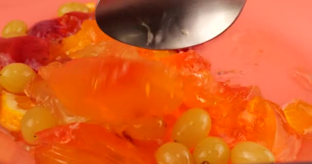 Vielfarbiges Beerengelatine Gelee Mit Orangen Und Kiwi Scheiben Auf Rosa — Stockvideo