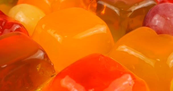 Spadające Krople Soku Pomarańczowego Galaretkę Żelatynową Wielobarwną Winogronami Plasterkami Pomarańczy — Wideo stockowe