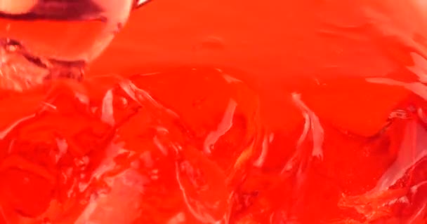 분홍색 배경에는 젤라틴 젤리가 있습니다 숟가락에 조각들 — 비디오