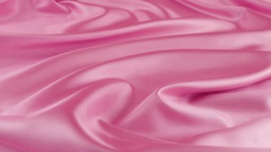 Beyaz kuğu tüyleri pembe ipeğe düşer. Yavaş çekim.