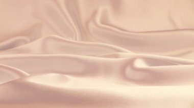 Beyaz kuğu tüyleri soluk bej ipeğin üzerine düşer. Yavaş çekim.