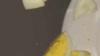 Dilimlenmiş yumurta parçaları cam bir yüzeye düşer..