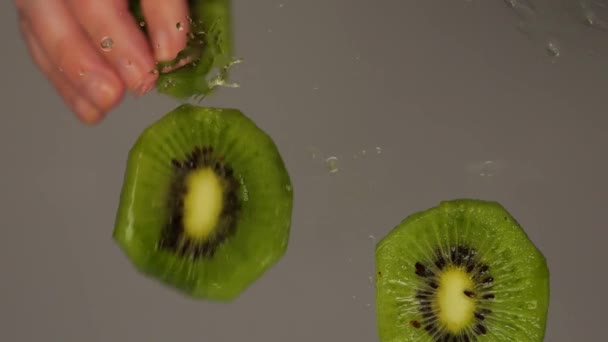 Fette Kiwi Affettate Cadono Sulla Superficie Del Vetro Dalle Mani — Video Stock