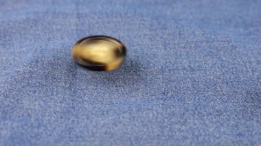 Natural bone color buttons fall on denim. Slow motion.