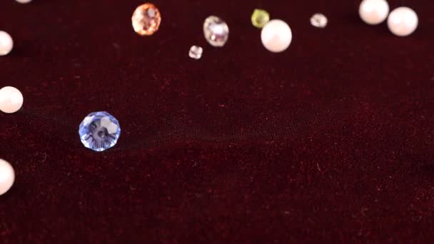 彩色透明珠宝水晶和白色珍珠落在勃艮第天鹅绒上 慢动作 — 图库视频影像