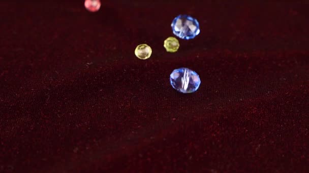 Flerfärgade Transparenta Smycken Kristaller Faller Vinrött Sammet Långsamma Rörelser — Stockvideo