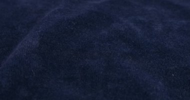 Clear white jewelry crystals and rhinestones fall on blue velvet.