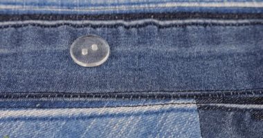 Plastic transparent buttons fall on denim.