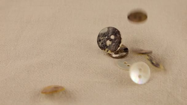 珍珠钮扣的天然母亲落在米色的天然亚麻织物上 慢动作 — 图库视频影像