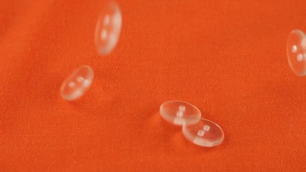 Plastic Transparent Buttons Fall Orange Cotton Fabric Slow Motion — Stockvideo
