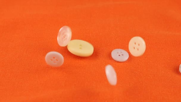 Plastic Multi Colored Buttons Fall Orange Cotton Fabric Slow Motion — Stockvideo