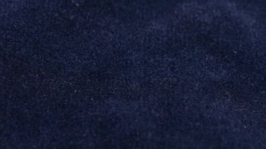 Clear white jewelry crystals and rhinestones fall on blue velvet.