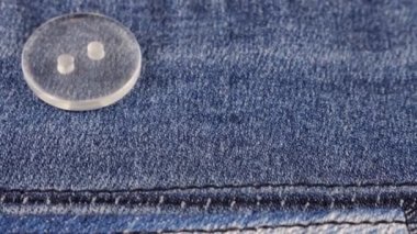 Plastic transparent buttons fall on denim.