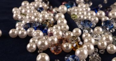 Transparent white and multi-colored jewelry crystals, rhinestones and pearls on blue velvet.