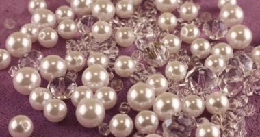 White pearls, clear jewelry crystals and rock crystal on pink velvet.