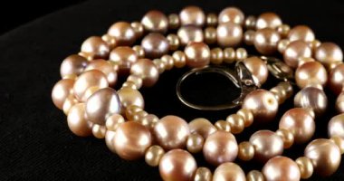 Necklace and silver ring made of natural sea pearls on black velvet.