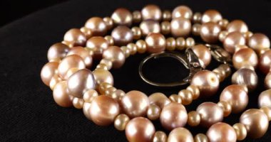 Necklace and silver ring made of natural sea pearls on black velvet.