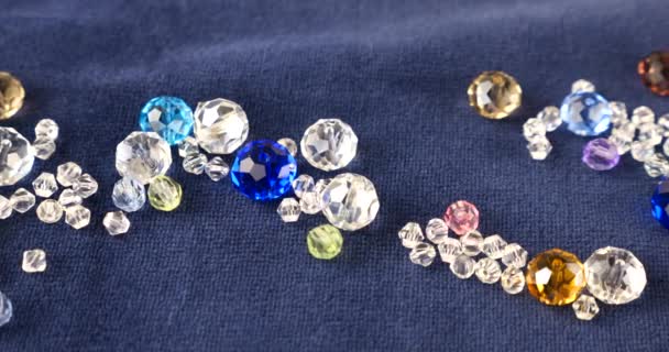 蓝色天鹅绒上的多色透明珠宝晶体和石晶 — 图库视频影像