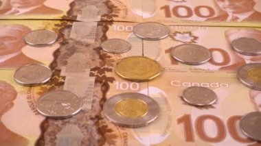 Canadian coins and 100 dollar polymer banknotes with a portrait of Robert Borden.