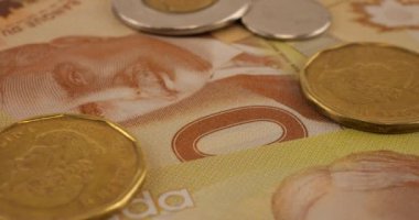 Canadian coins and 100 dollar polymer banknotes with a portrait of Robert Borden.