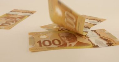 Falling Canadian 100 dollar polymer banknotes with a portrait of Robert Borden.