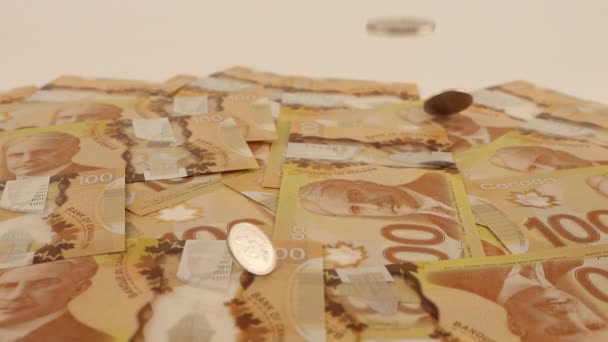 ロバート ボーデンの肖像画と100ドルのポリマー紙幣にカナダの硬貨を落下させる スローモーション — ストック動画