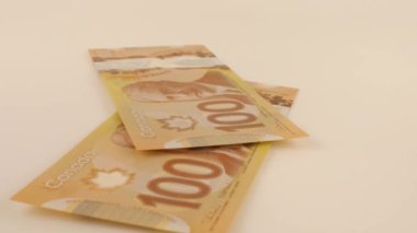 Falling Canadian 100 dollar polymer banknotes with a portrait of Robert Borden.