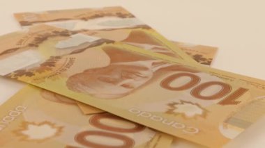 Falling Canadian 100 dollar polymer banknotes with a portrait of Robert Borden.