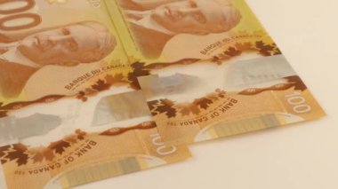 Falling Canadian 100 dollar polymer banknotes with a portrait of Robert Borden.