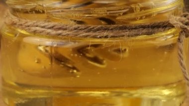 Honey flows from a spoon spindle into a jar of honey on the background of a jug of lemonade and ginger. Video on the topic of immunity and health.