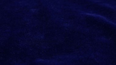 Transparent white jewelry crystals, rock crystal and pearls fall on blue velvet.