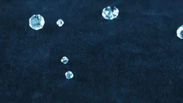透明なジュエリー結晶とロッククリスタルは青ベルベットの上に落ちる スローモーション — ストック動画