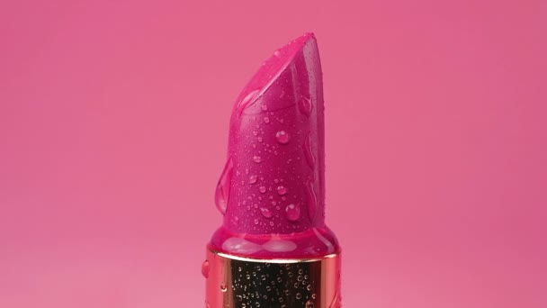 Red Lipstick Tube Water Drops Isolated Pink Background — 图库视频影像