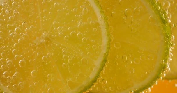 Ripe Lime Slices Air Bubbles Orange Background — Vídeos de Stock