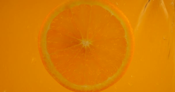 Кусок Апельсина Заполнен Водой Пузырьками Воздуха Оранжевом Фоне — стоковое видео