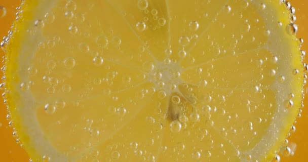 Eine Scheibe Reife Zitrone Luftblasen Auf Orangefarbenem Hintergrund — Stockvideo