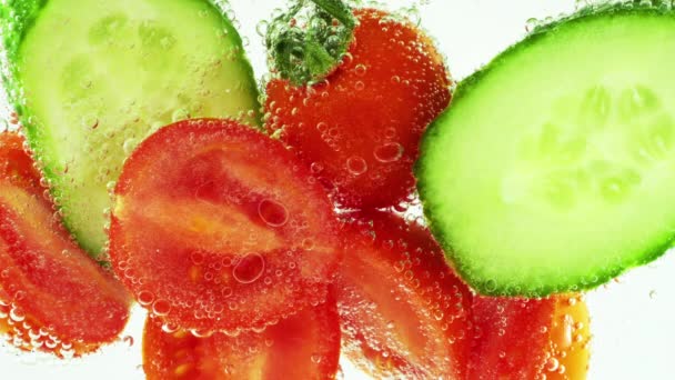Slices Fresh Cucumbers Tomatoes Clear Water Air Bubbles — Stockvideo
