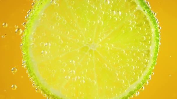 Slice Ripe Lime Air Bubbles Orange Background — Stockvideo