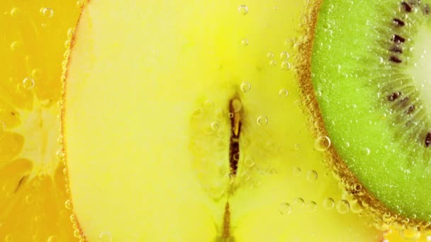 Skivor Mogen Apelsin Äpple Och Kiwi Klart Vatten Luftbubblor — Stockvideo