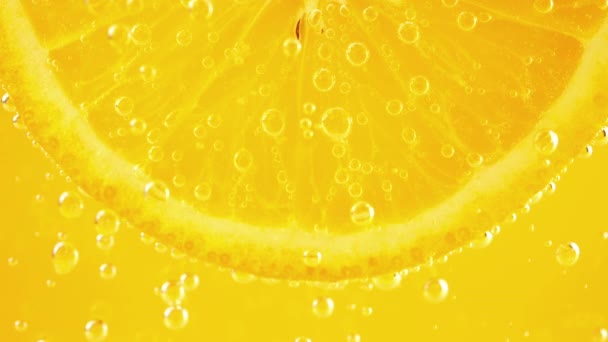 Шматочок Стиглого Апельсина Водяних Бульбашках Помаранчевому Фоні — стокове відео