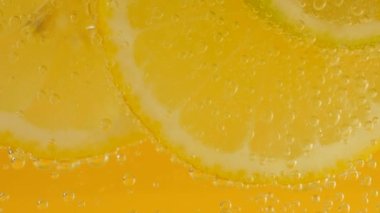 Ripe citrus lemonade, orange, lemon, lime slices in air bubbles.