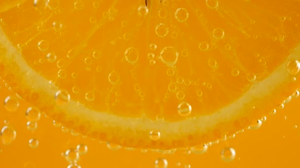Kawałek Dojrzałej Pomarańczy Bąbelkach Wody Pomarańczowym Tle — Wideo stockowe